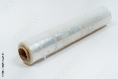 transparent film for packaging goods on a white background. film to protect the box from damage on a light background. cling film on roll