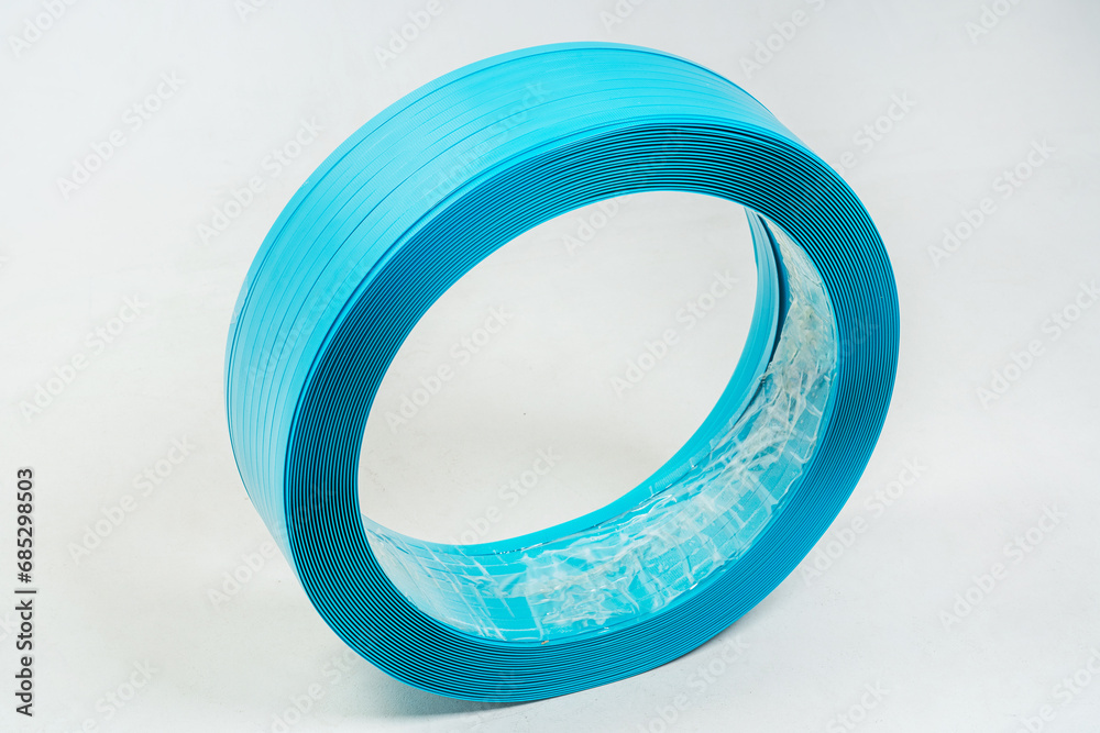 blue polyester tape on a white background. high-strength temoplastic tape in a roll on a light background. tape packaging material in roll blue polyester tape on a white background. high-strength temoplastic tape in a roll on a light background. tape packaging material in roll