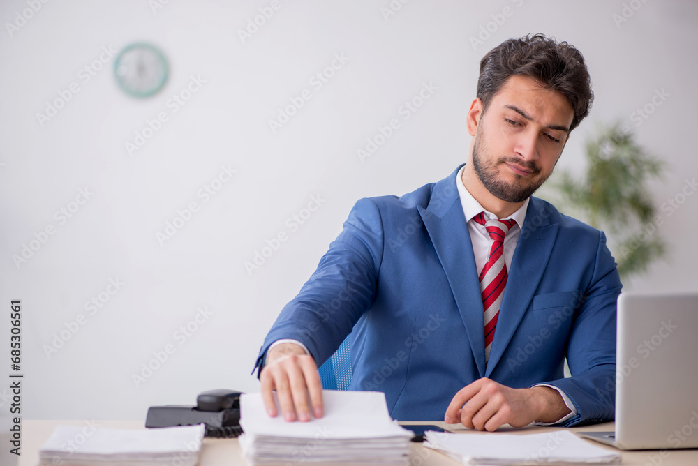 Young male employee working in the office Young male employee working in the office