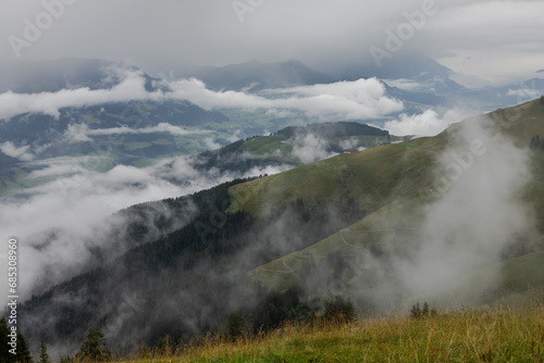 alpine valley view with clouds and fog