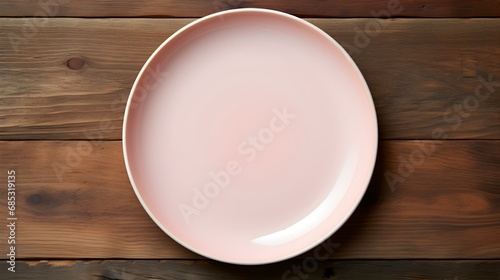 Top View of an empty Plate in light pink Colors on a wooden Table. Elegant Template with Copy Space