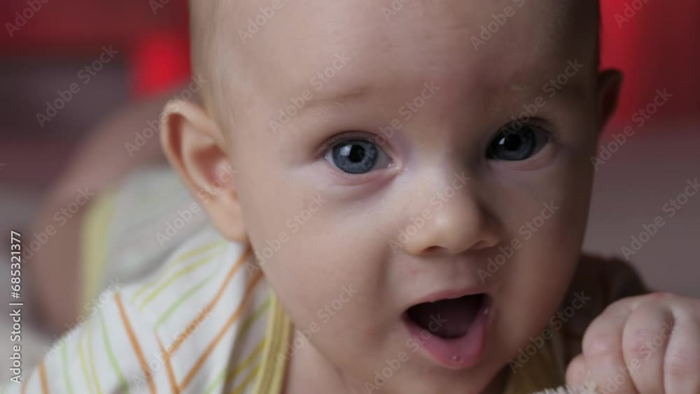 A nice little newborn baby is funny smiling, lying at the back in the child crib. A nice little newborn baby is funny smiling, lying at the back in the child crib.