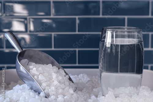 Foto Glass of water and water softener salt for hard water treatment concept