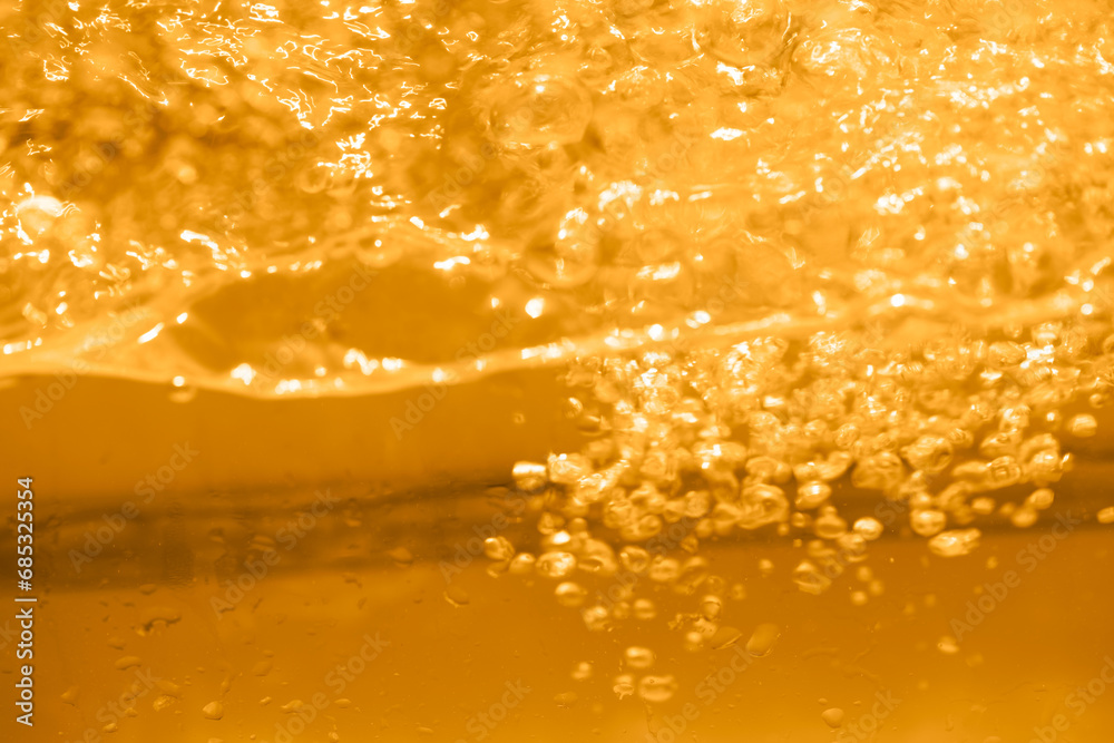Yellow water with ripples on the surface. Defocus blurred transparent gold colored clear calm water surface texture with splashes and bubbles. Water waves with shining pattern texture background. Yellow water with ripples on the surface. Defocus blurred transparent gold colored clear calm water surface texture with splashes and bubbles. Water waves with shining pattern texture background.