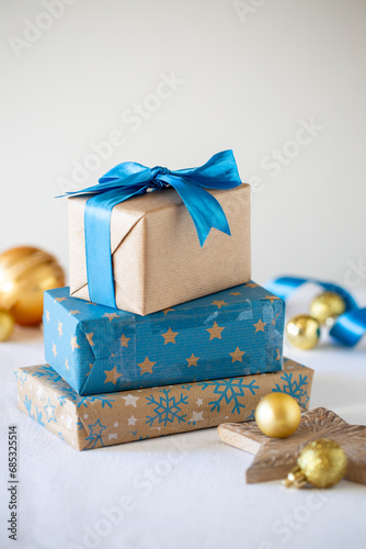 Pacchetti di scatole regalo di Natale color blu e oro e sullo sfondo palline dorate di Natale