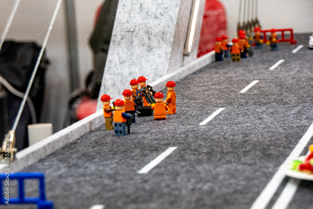 Builders for road works on the bridge. Toy composition.