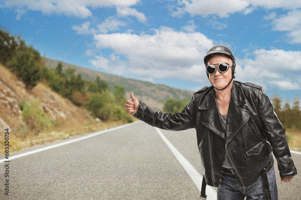 Mature hitchhiker in a black leather jacket and helmet