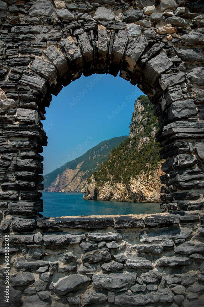 View on the sea and rocks through the window of the Middle Ages fortress in the city of Portovenere, Italy