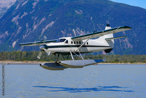 Seaplane taking off from a melt water lake in the Alaskan mountains north of Juneau in the Taku inlet photo