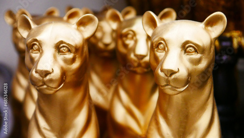 Close-up of many golden decorative figurines of panthers