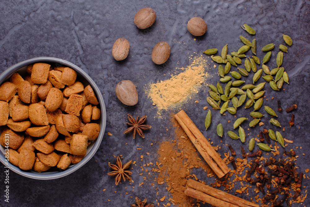 Flat lay of spices on a dark background. Top to bottom Nutmeg, White pepper, Cardamom, Cloves, Star Anise, Cinnamon. Flat lay of spices on a dark background. Top to bottom Nutmeg, White pepper, Cardamom, Cloves, Star Anise, Cinnamon.