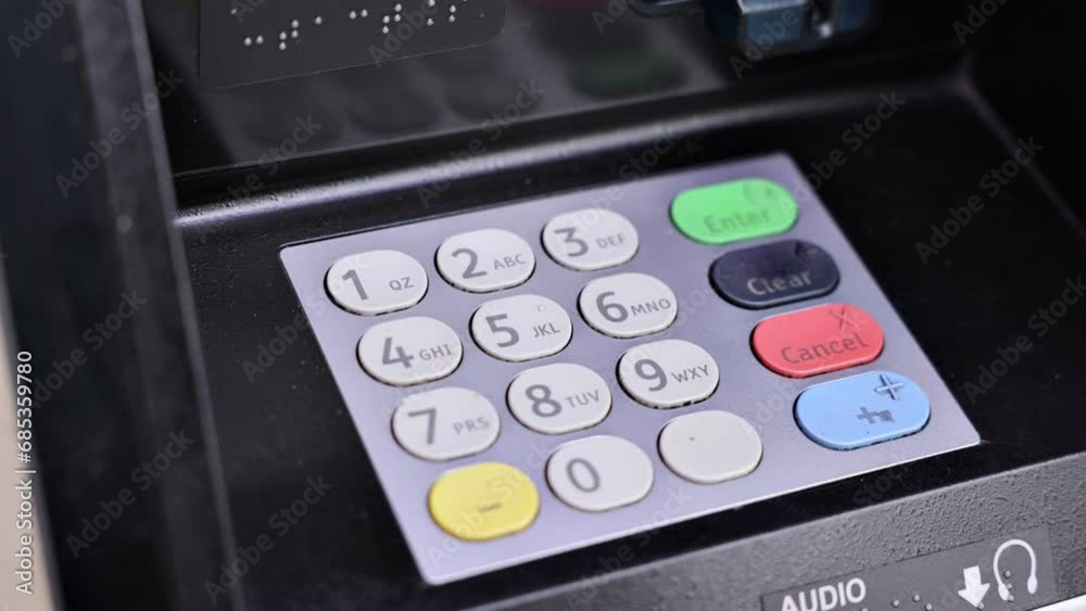 Getting money from an ATM. Entering pin number on the keypad. Getting money from an ATM. Entering pin number on the keypad.