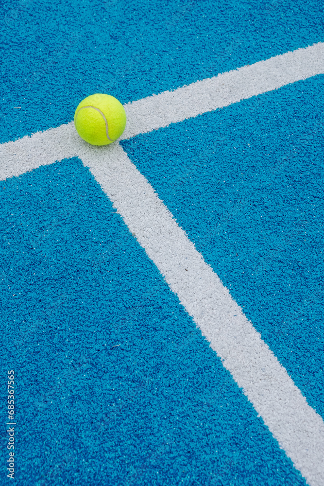 blue paddle tennis court with a ball on the line