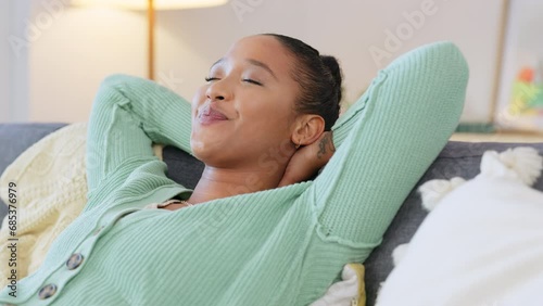 Carefree African American female lying back, stressless and content. Lady with no worries enjoying a day indoors. Happy black woman enjoying the freedom to relax on a sofa at home. photo