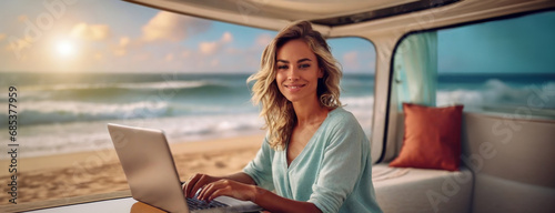 Living and working inside camper van vehicle in travel and digital nomad free lifestyle. Smiling woman sitting in a motorhome and enjoy relax with laptop. Beach background outside the window. photo