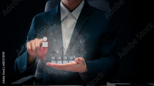 Conceptual image of selecting people for higher positions, the HR manager is selecting employees to rise to higher positions. ,Businessman uses finger to touch graphic people icon.