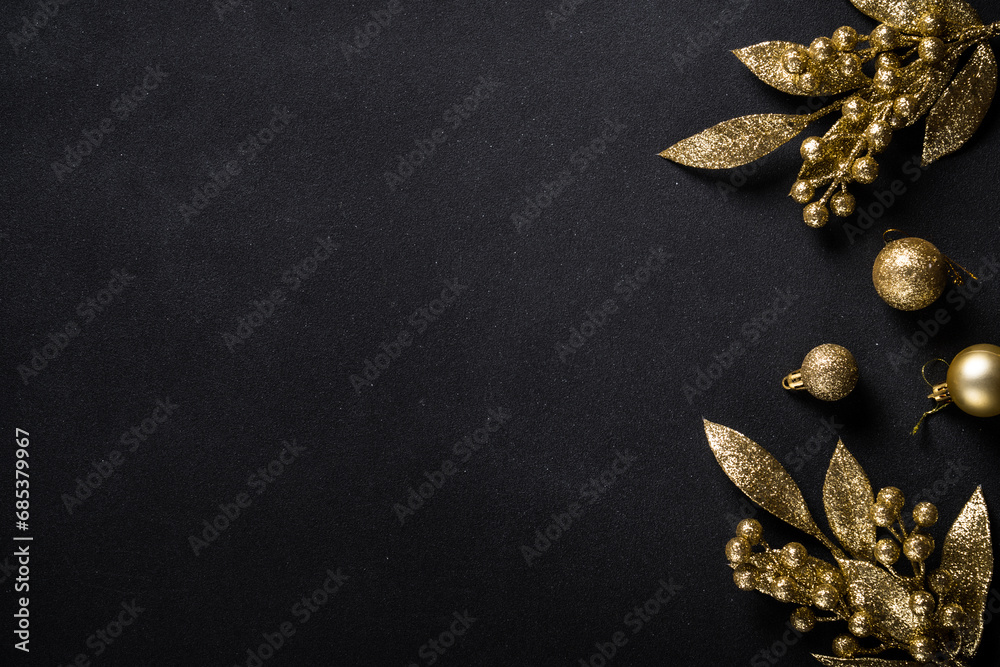 Naklejka premium Christmas gold decorations on black background. Top view image with copy space.