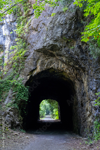 Fototapeta Naklejka Na Ścianę i Meble -  New River Trail Bicycle Greenway in Virginia Passing through A Rock Cliff with a Tunnel in the Mountainside