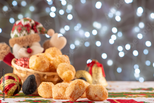 Santa Claus and cheese bread, happy Santa Claus with cheese breads in Brazil and in the background beautiful Christmas lights totally out of focus, selective focus photo