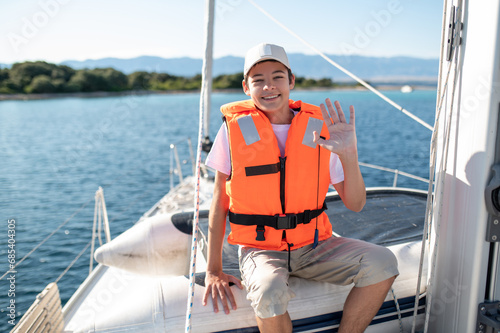 Smiling boy in a life-jacket on the boat