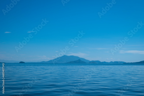 Blue Coastline Seen From Afar with a Volcanic Mountain, Lush Vegetation Forest and a Calm Ocean