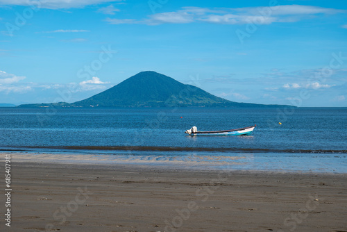 Obraz na płótnie Volcanic Island, Boat and Beach with Lush Vegetation Forest Around Beautiful and Calm Ocean w salonie