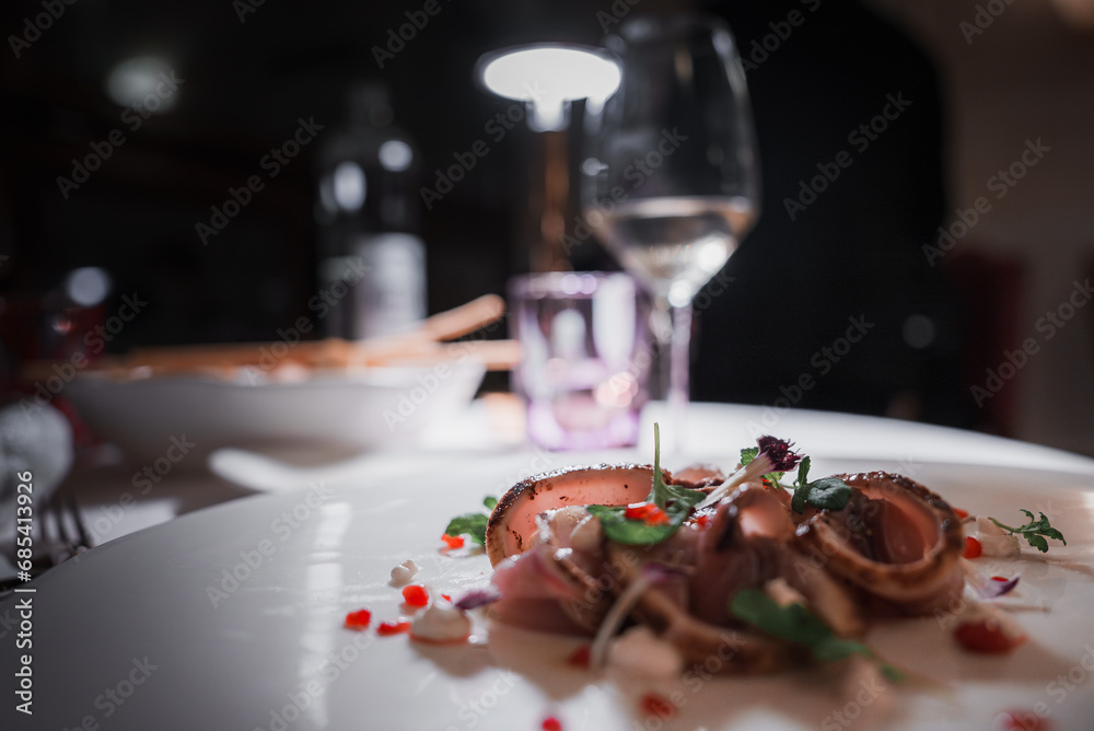 Close-up shot of a delicious meal with a glass of wine on a table. Perfect for dining, restaurant, and food and drink concepts.