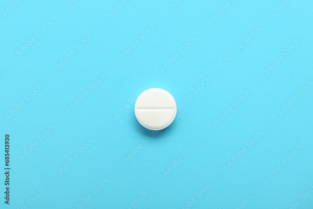 White medical pill on blue background White medical pill on blue background