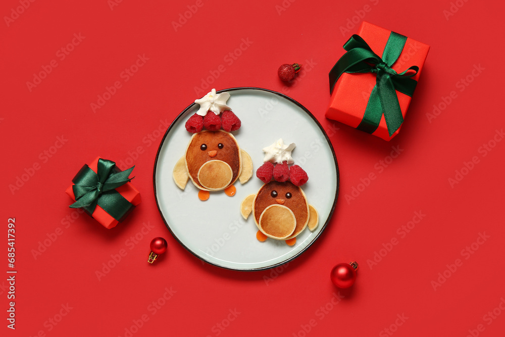 Plate with pancake in shape of penguins on red background. Christmas celebration Plate with pancake in shape of penguins on red background. Christmas celebration