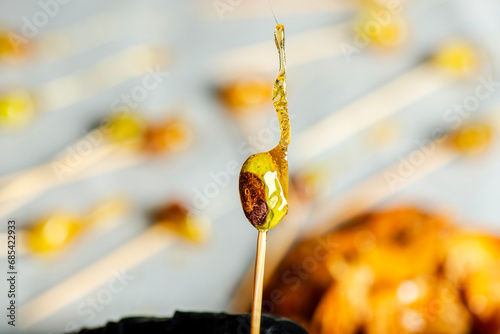 In the kitchen showing the process of caramelising pistachios for decoration. photo