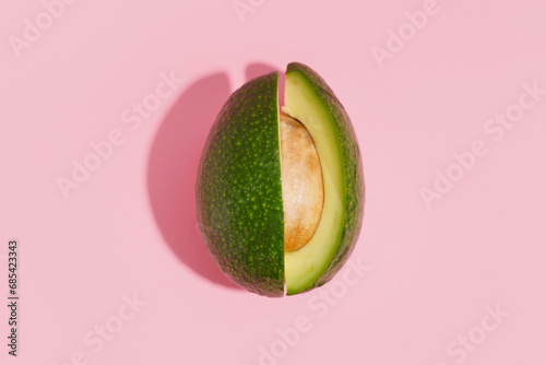 Cut fresh avocado on pink background