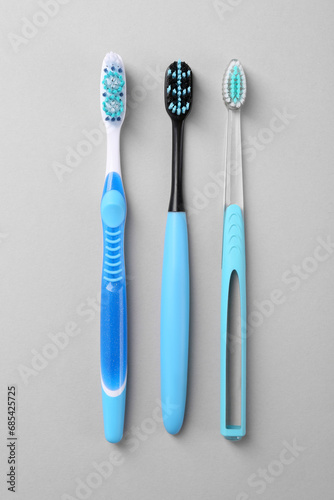 Many different toothbrushes on light background  flat lay