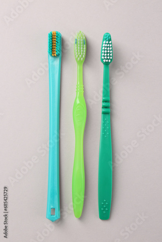 Many different toothbrushes on light background  flat lay