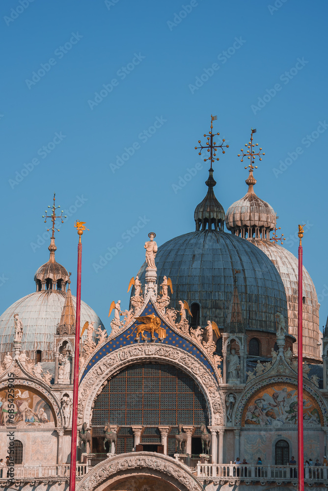 Ornate Gothic cathedral in Venice, Italy, with stunning architectural details and towering spires against a blue sky. A standout landmark in the city.