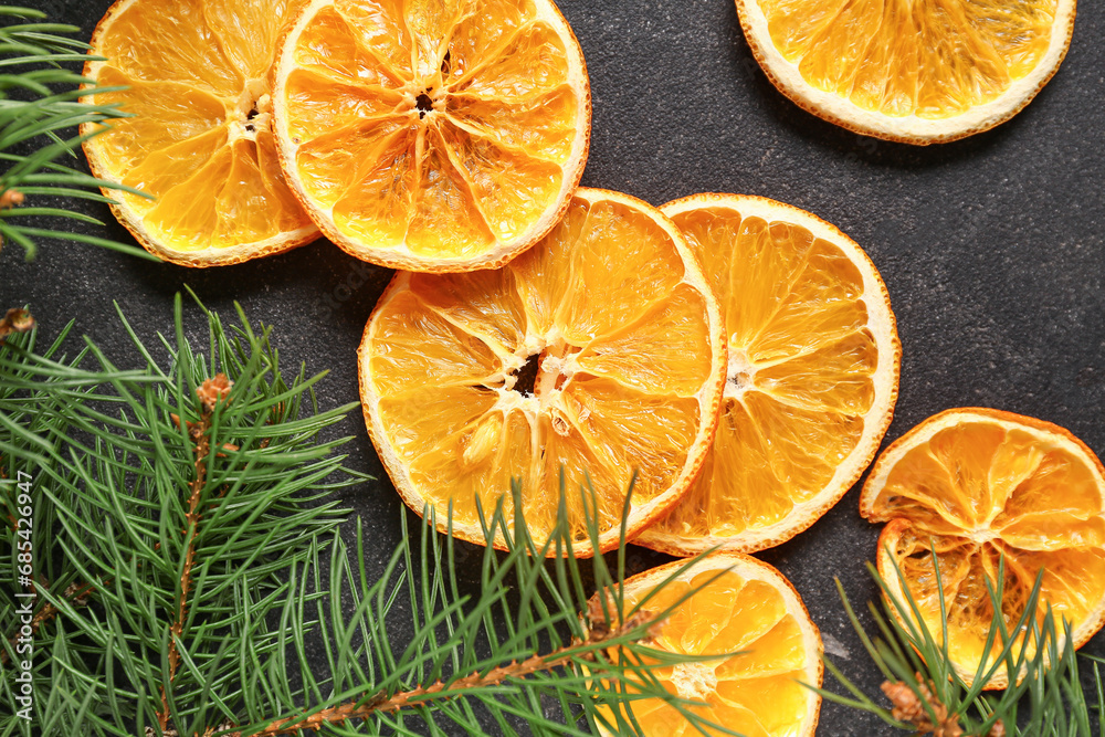 Dried orange slices and fir branches on black background Dried orange slices and fir branches on black background