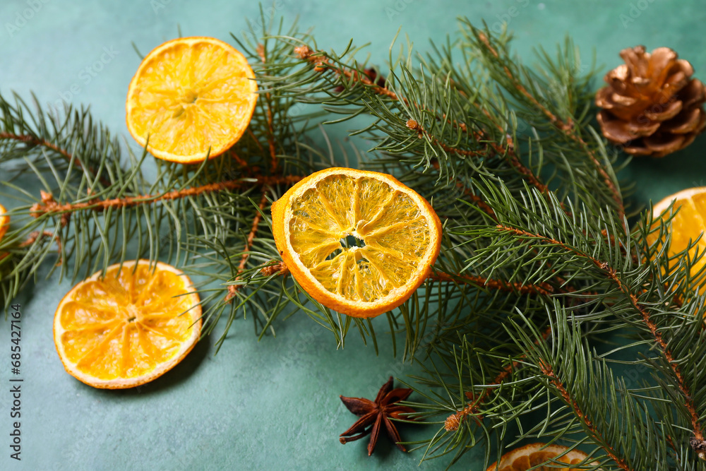 Dried orange slices with fir branches, star anise and pine cone on green background Dried orange slices with fir branches, star anise and pine cone on green background