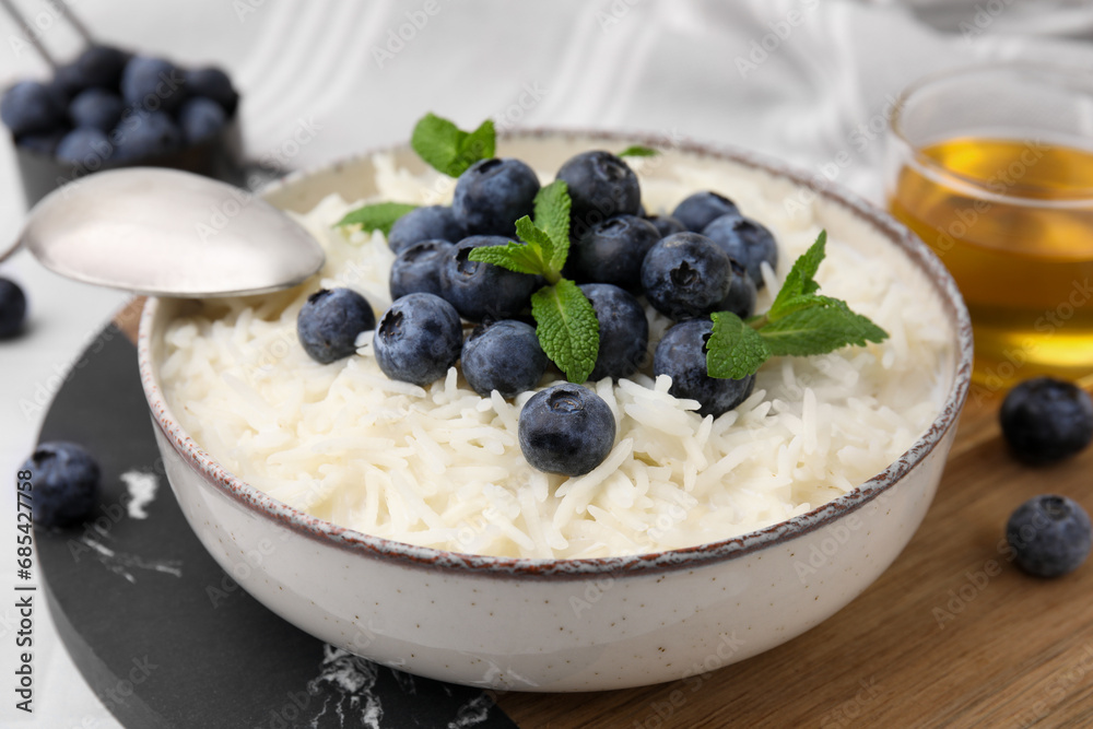 Bowl of delicious rice porridge with blueberries and mint served on table, closeup Bowl of delicious rice porridge with blueberries and mint served on table, closeup
