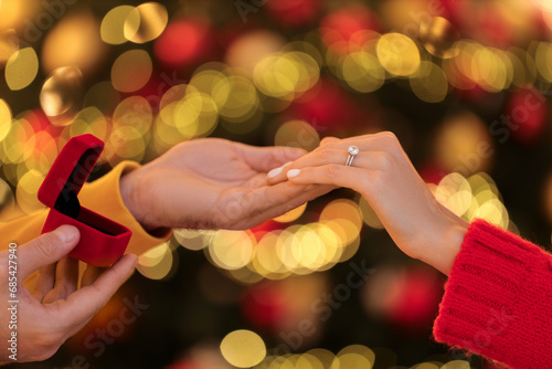 Making proposal. Woman with engagement ring and her fiance holding hands against blurred lights, closeup © New Africa