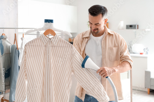 Handsome man steaming shirt...