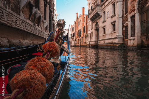 A gondola navigates through the picturesque canals of Venice, Italy. This image captures the iconic scene of a gondola on the waterways of Venice. © ingusk