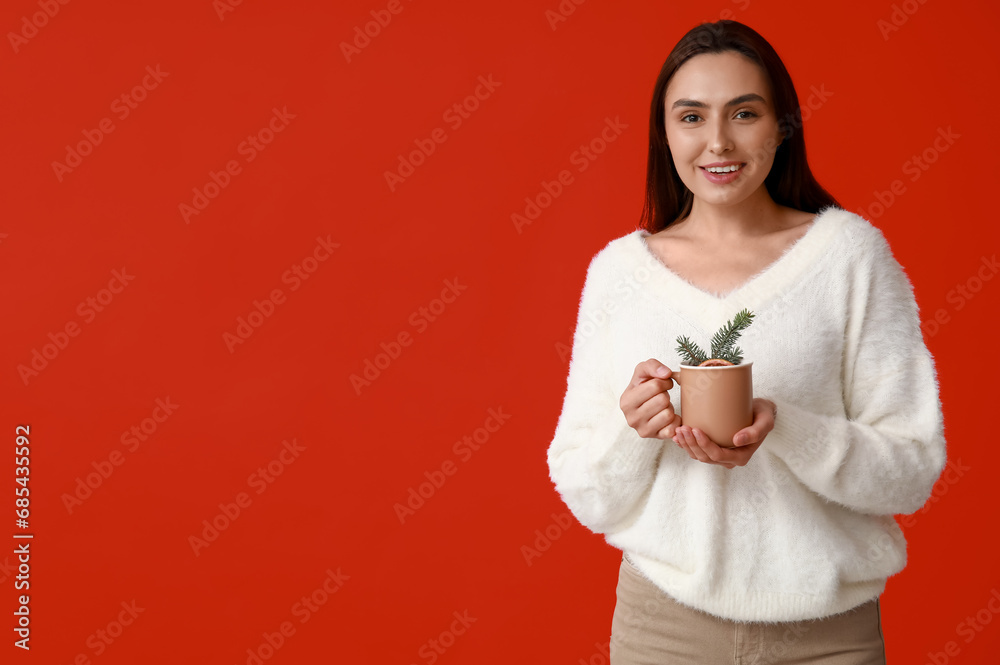 Happy young woman with cup of hot mulled wine on red background Happy young woman with cup of hot mulled wine on red background