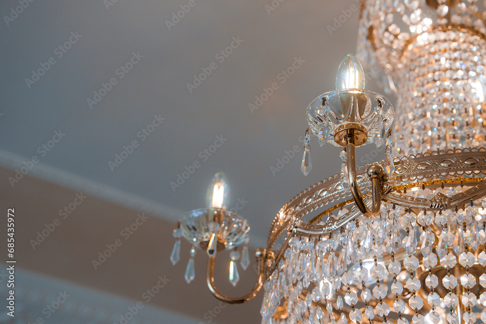 An opulent gold chandelier, a focal point in a Venetian-style room, exudes grandeur and sophistication. When illuminated, it provides a luxurious ambiance. Ideal for luxury hotel and restaurant decor.