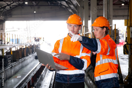 Young caucasian engineer man and woman checking train with laptop in station, team engineer inspect system transport, technician examining infrastructure, transportation and industry.