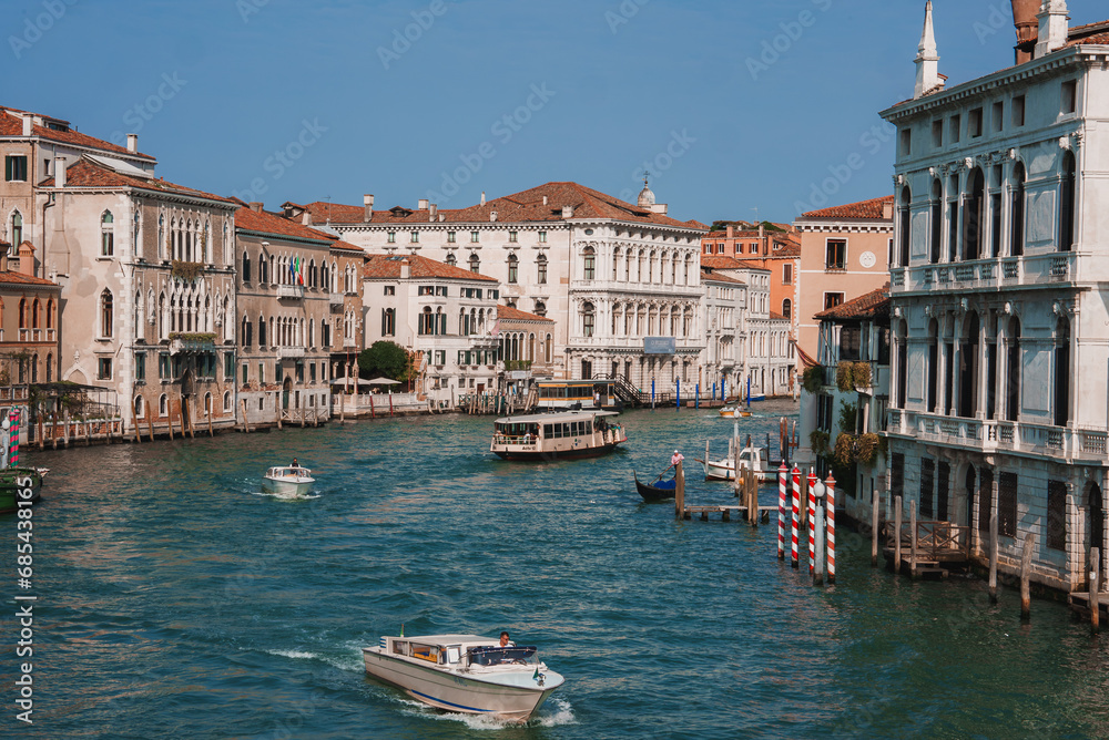 Scenic view of the serene Grand Canal in Venice, Italy, with boats traveling on the water and buildings lining the canal, capturing the beauty and charm of the iconic waterway.