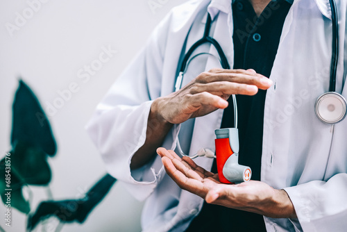 Male doctor holding asthma inhaler in the clinic. Medical equipment concept photo