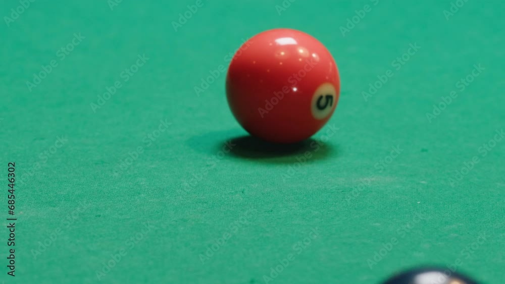 Young man breaking colorful pool balls with cue on green billiards table for start to play. American pool, poule game. Billiard balls with numbers on a pool table. Billiards team sport. Young man breaking colorful pool balls with cue on green billiards table for start to play. American pool, poule game. Billiard balls with numbers on a pool table. Billiards team sport.