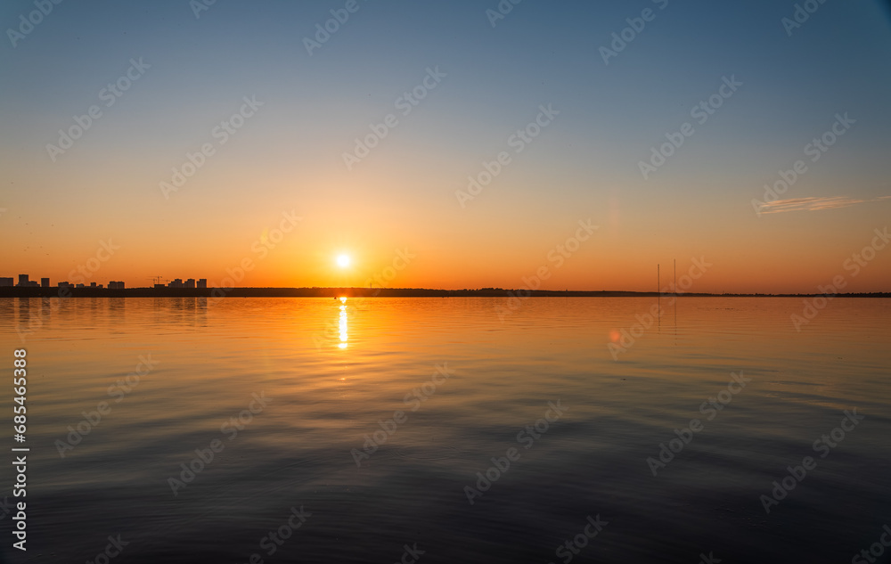 Obraz premium Lake with pine and birch forest on the shores at summer or early autumn sunset.