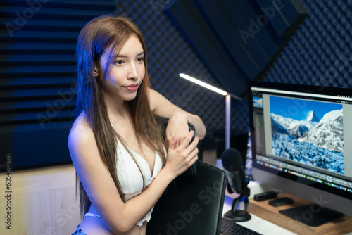 Sexy gamer or streamer girl sitting at home under neon lights.