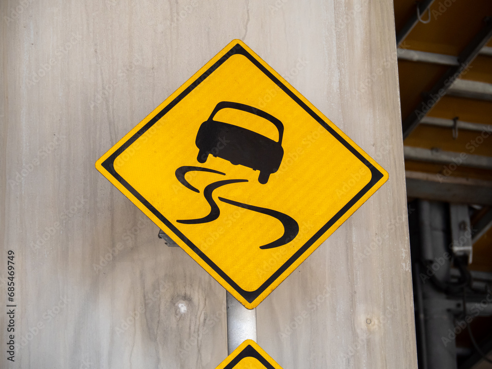 道路標識(警戒標識)「すべりやすい」。
