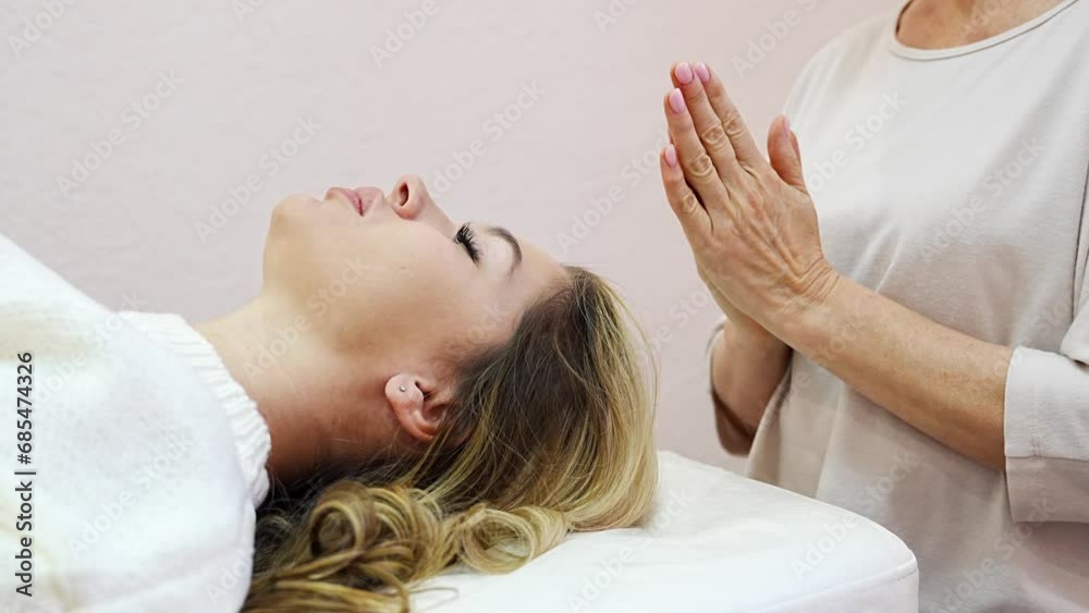 Healer performing by lightly touched set of 32 points of access bars on young woman head, stimulating positive change thoughts and emotions. Alternative medicine concept